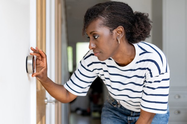 a person is adjusting the temperature on a thermostat