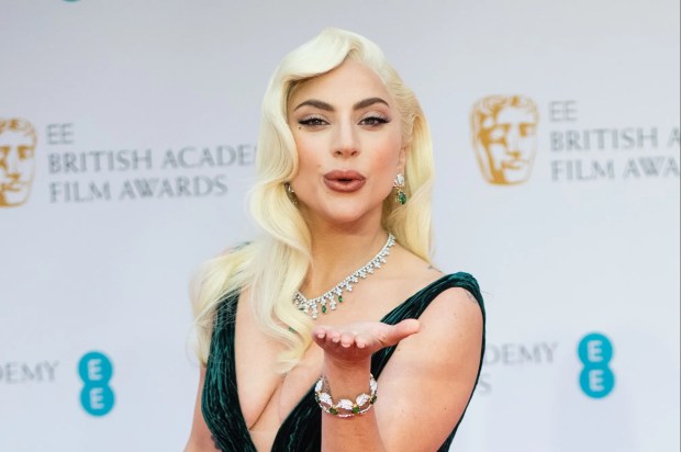 lady gaga blowing a kiss on the red carpet at the british academy film awards