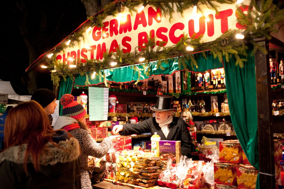 a man in a top hat is selling german christmas biscuits