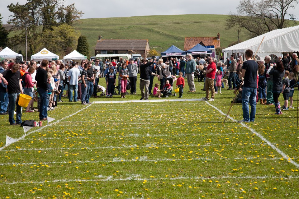 a group of people are gathered in a field with a tent that says ' a ' on it