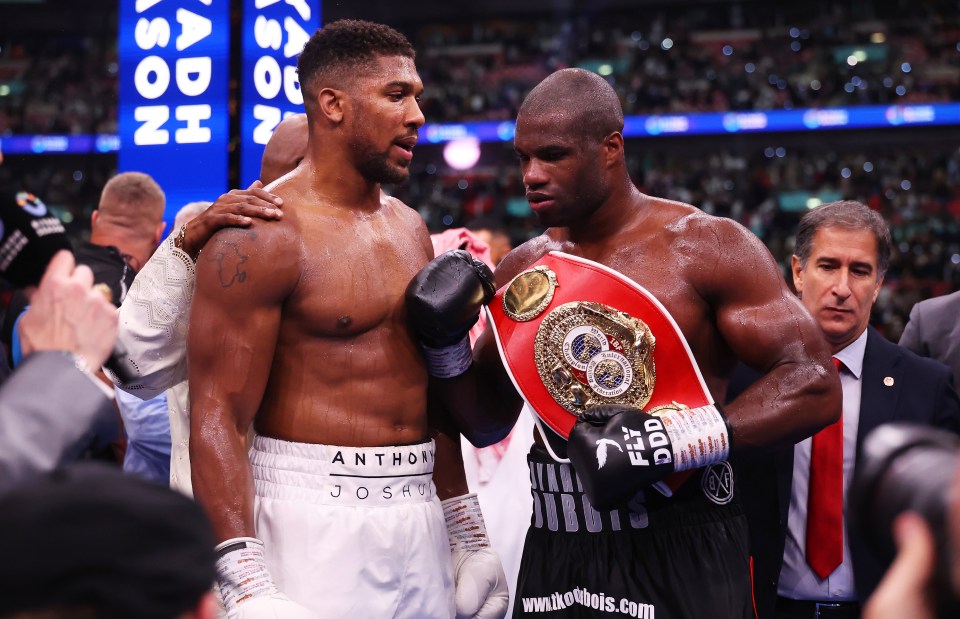 two boxers standing next to each other with one wearing a belt that says ford