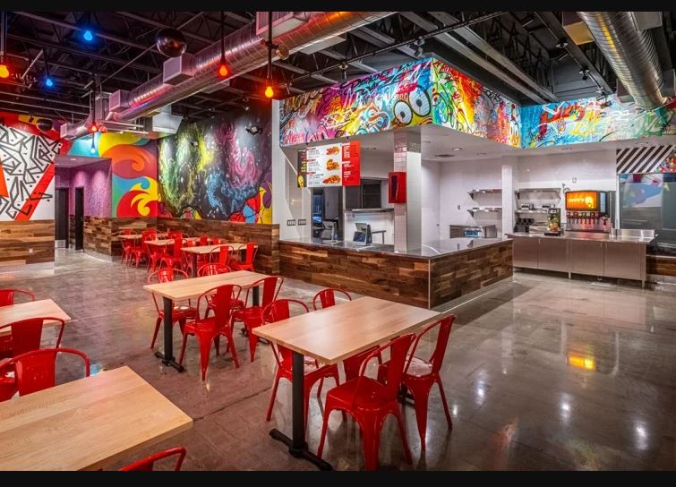 a restaurant with tables and chairs and a pepsi machine