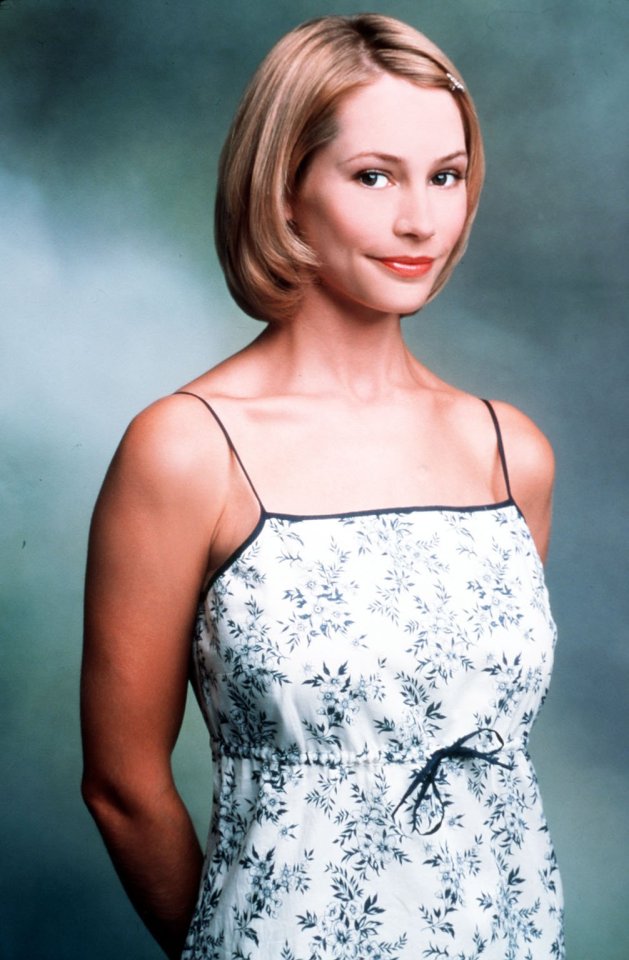 a woman in a floral dress is smiling for the camera