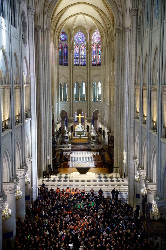 French President Emmanuel Macron deliver a speech amid attendees, including workers of reconstruction of Notre-Dame de Paris