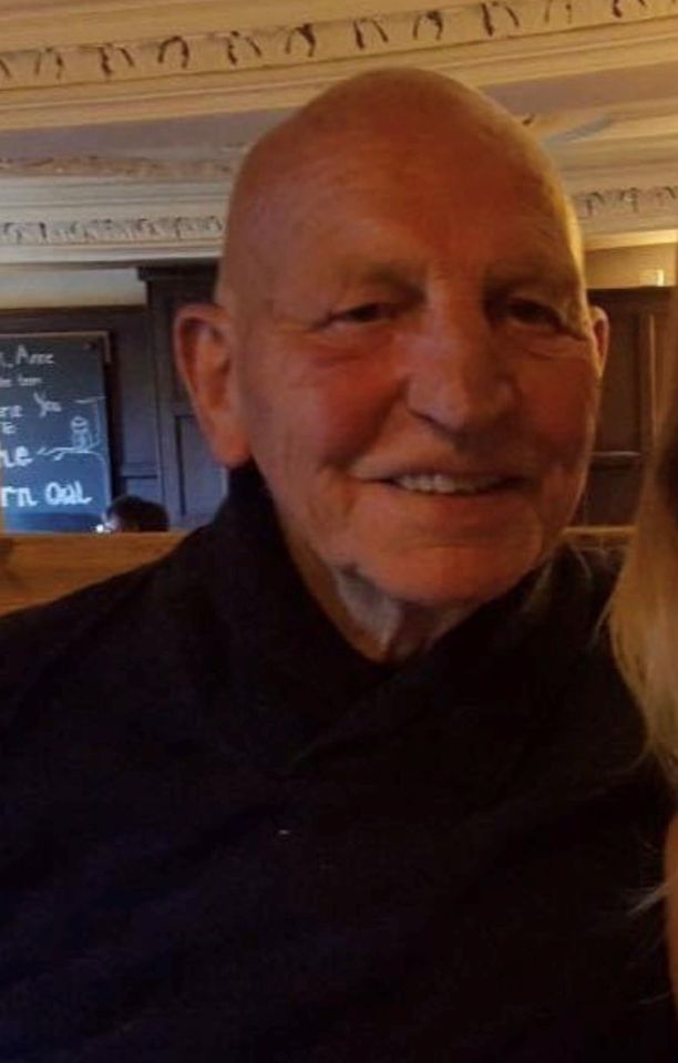 an elderly man with a bald head is smiling for the camera .