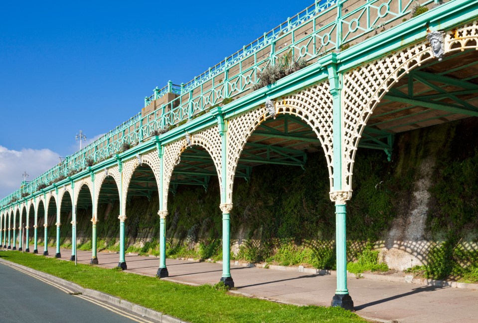 a row of green and white arches along a sidewalk