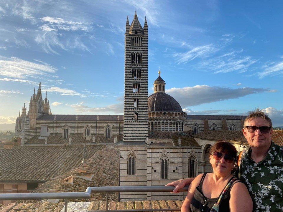 a man and woman standing in front of a large building