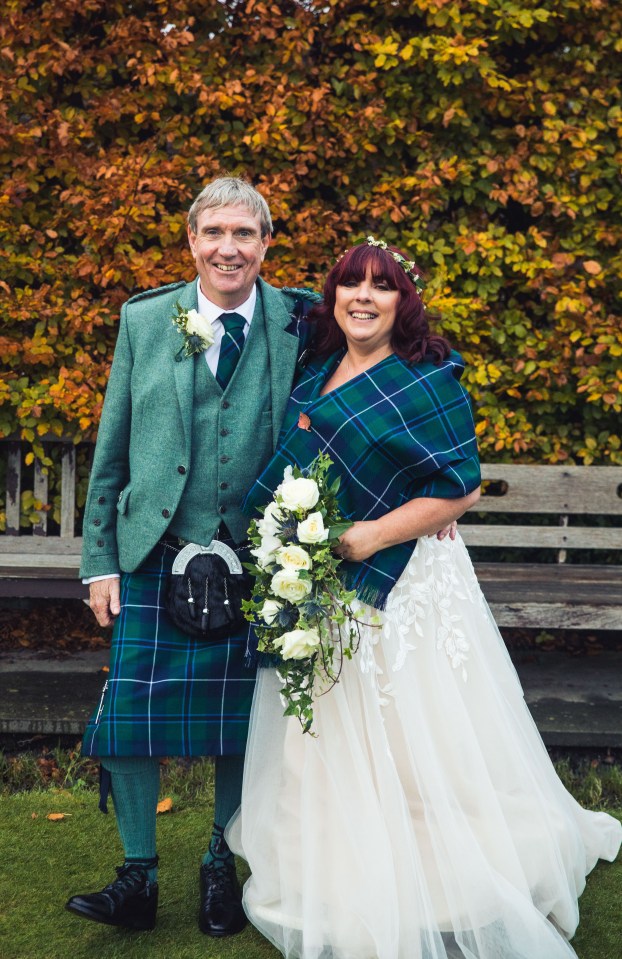 a man in a kilt stands next to a woman in a wedding dress