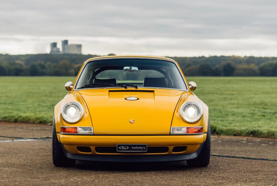 a yellow sports car with a sotheby 's sign on the front