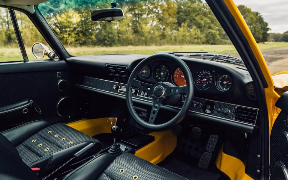 the interior of a yellow porsche with black seats