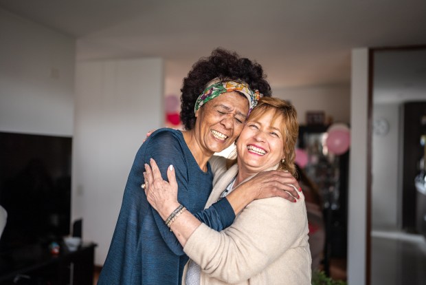 two women hugging each other and smiling for the camera