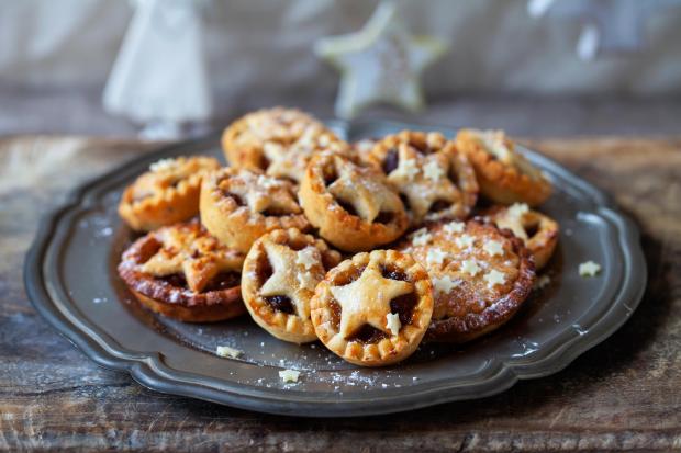 a plate of mince pies with powdered sugar on top