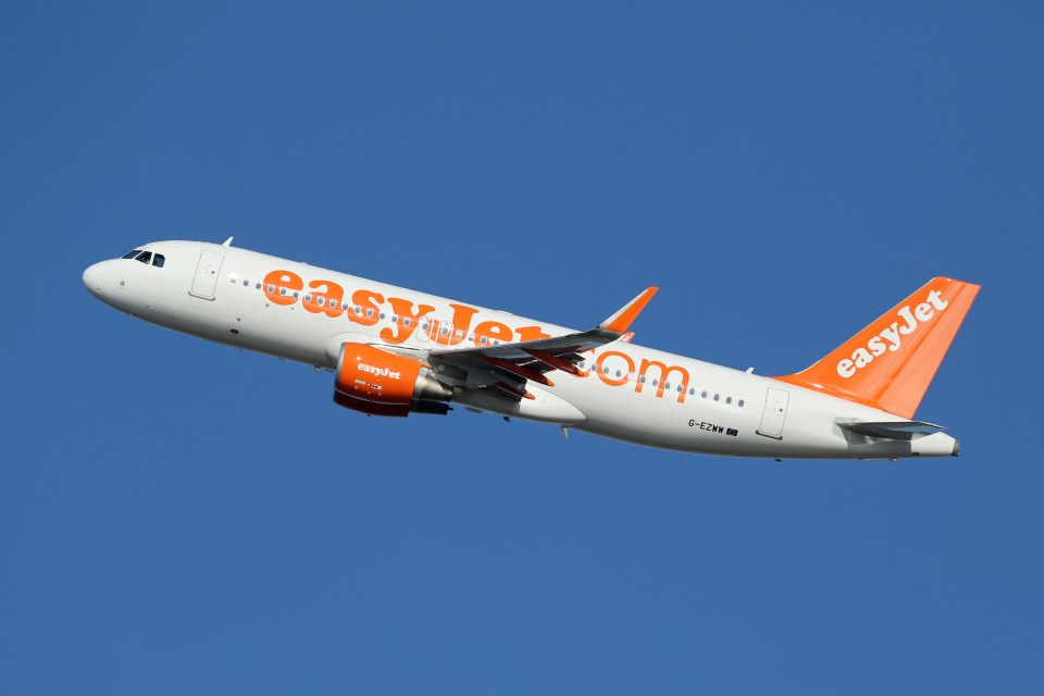 a white and orange easyjet airplane is flying in the sky