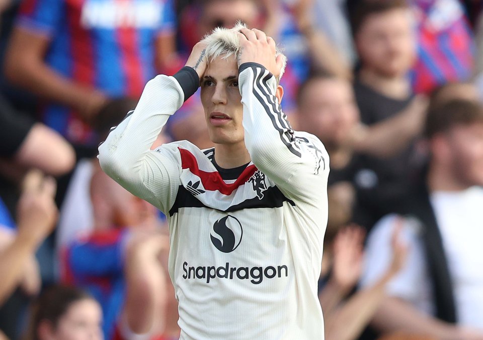 a soccer player wearing a snapdragon jersey holds his head