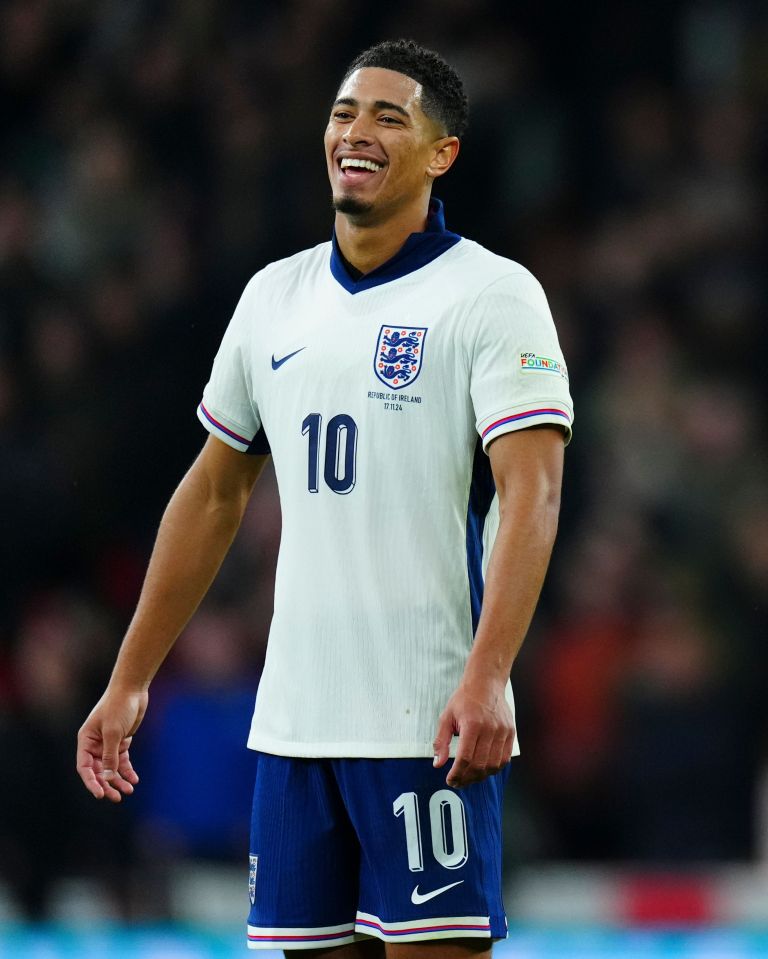 a man wearing a white shirt with a blue collar is smiling