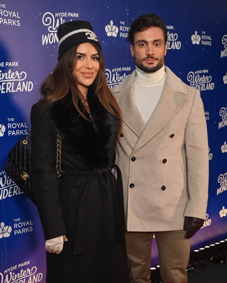 a man and woman are standing in front of a sign that says winter wonderland