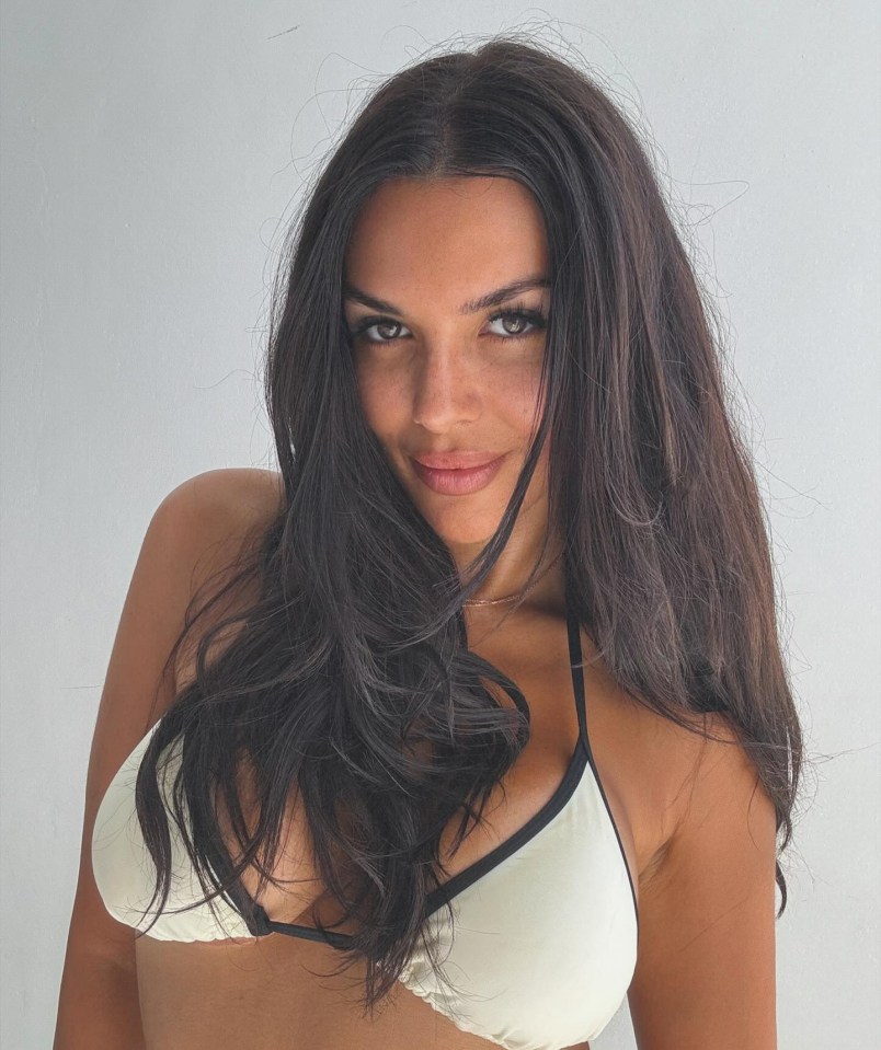 a woman with long dark hair is wearing a white bikini top