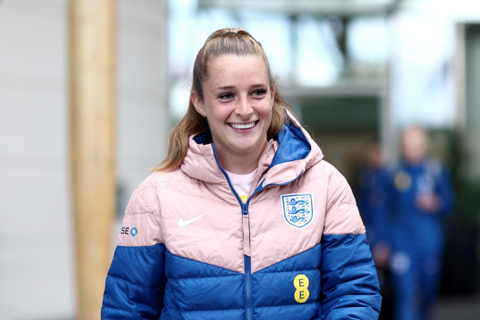 a woman wearing a pink and blue jacket with the letter e on it