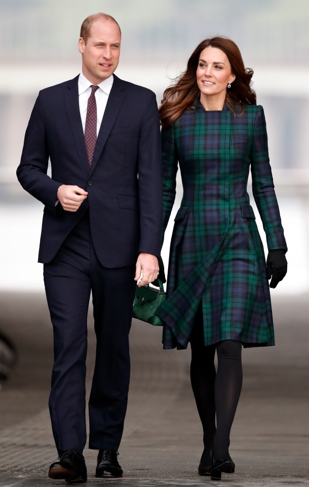 a man in a suit and tie walks next to a woman in a plaid dress