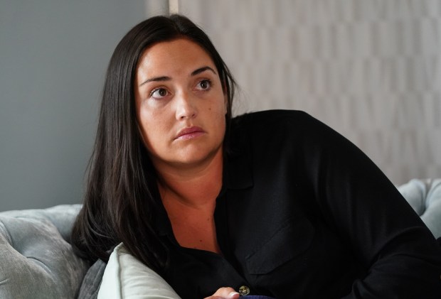 a woman in a black shirt sits on a couch