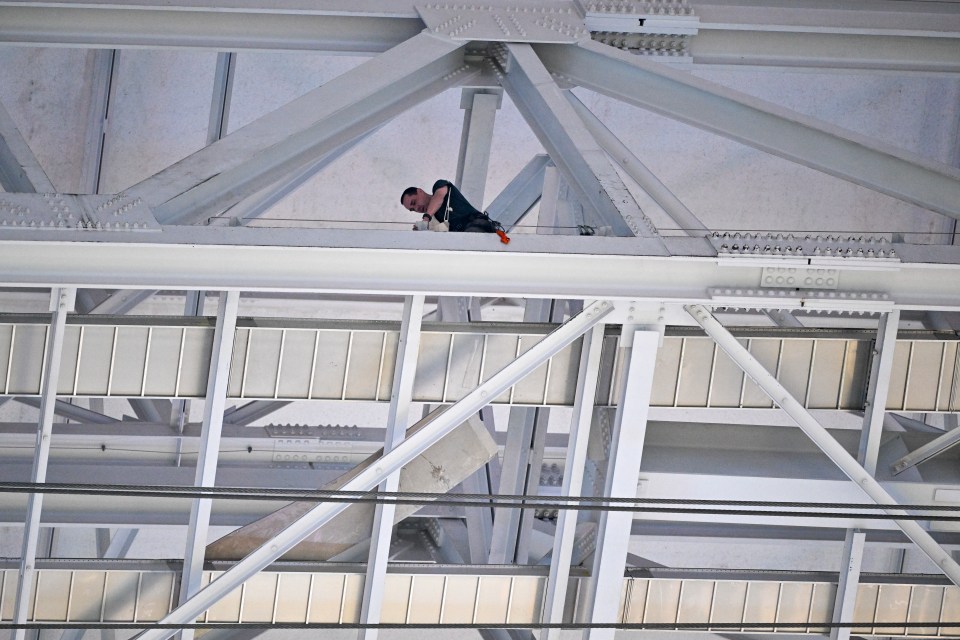 a man stands on top of a metal structure with the number 1 on it