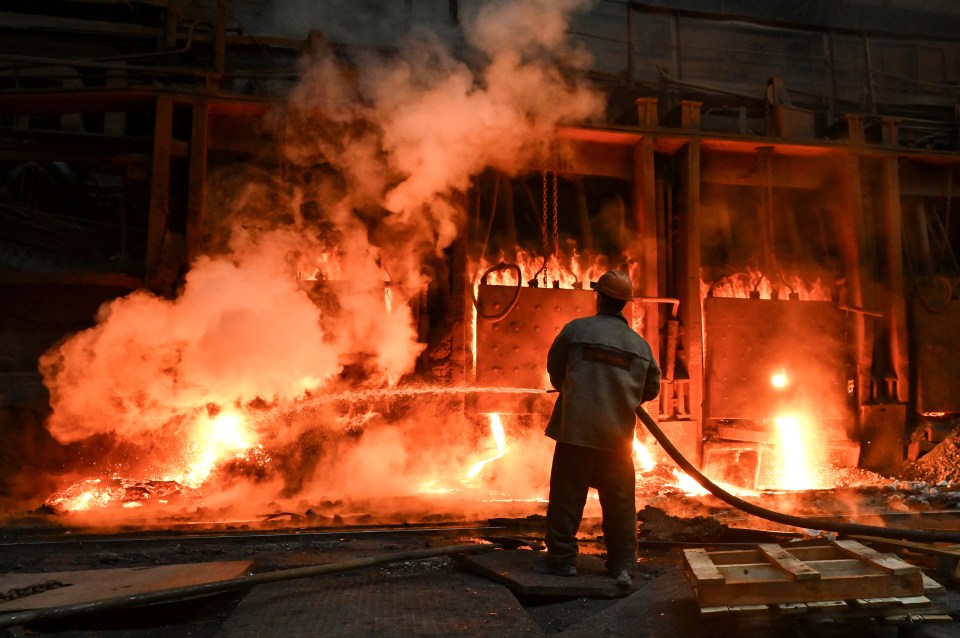 a man is standing in front of a fire with smoke coming out of it