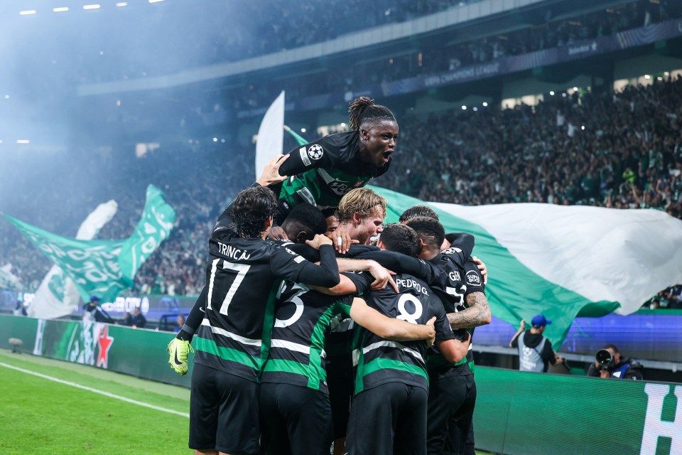 a group of soccer players are celebrating a goal with a heineken banner in the background