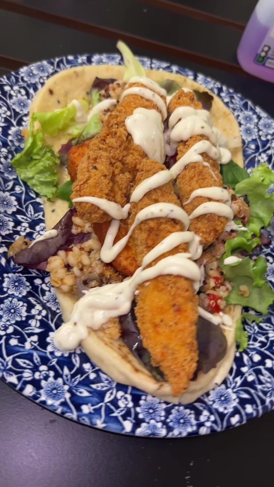 a blue and white plate with a fried chicken sandwich on it