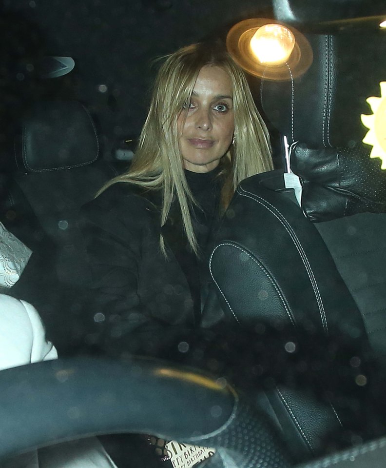 a woman sits in the back seat of a car