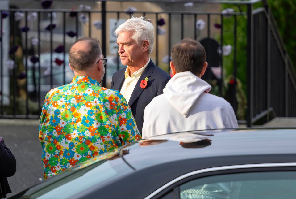 a man in a colorful shirt has a poppy on his head