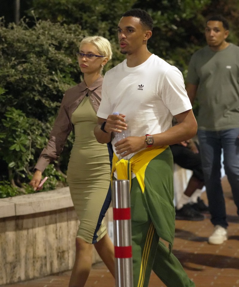 a man wearing a white adidas shirt walks with a woman