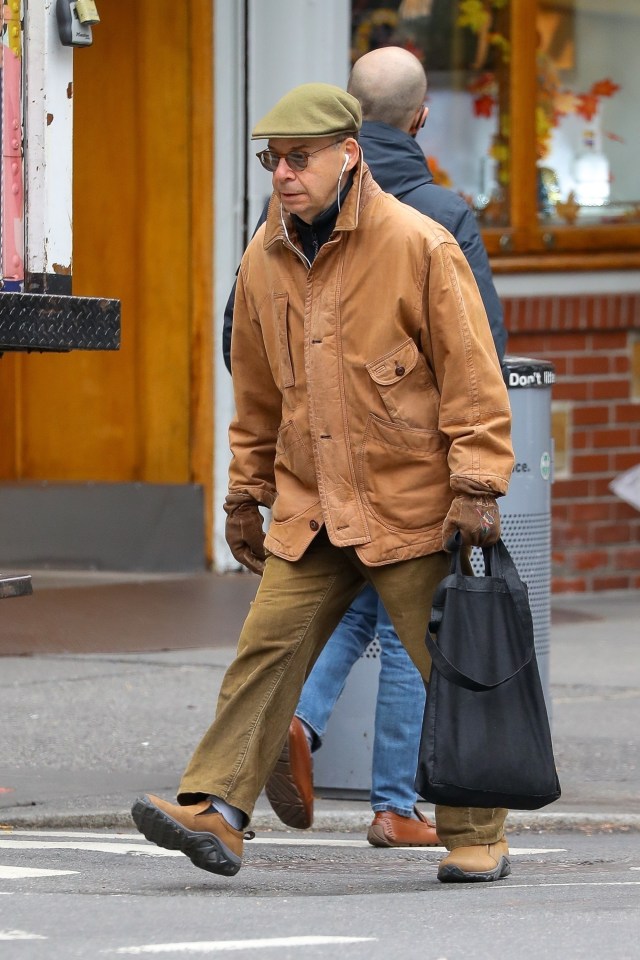 He had a concentrated expression as he picked up groceries with his earphones in