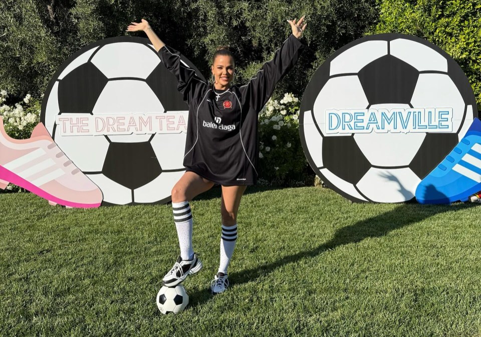 a woman stands in front of a sign that says dreamville