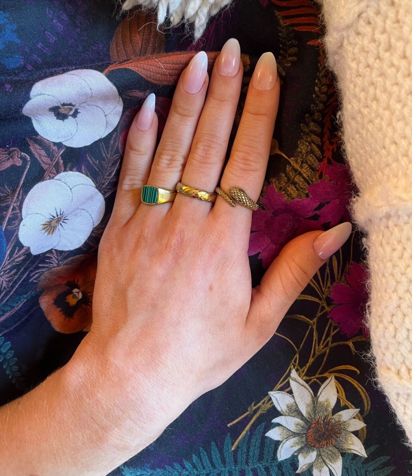 a woman 's hand with three rings on it