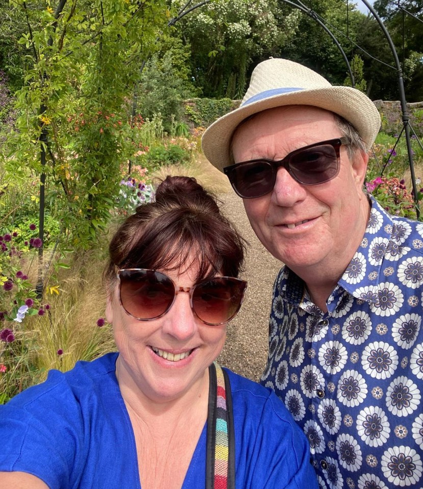 a man wearing a hat and sunglasses stands next to a woman wearing sunglasses