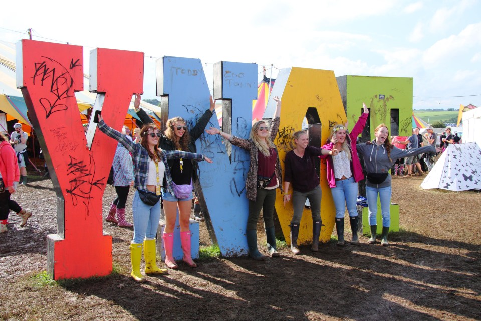 a group of people standing in front of a large y sign