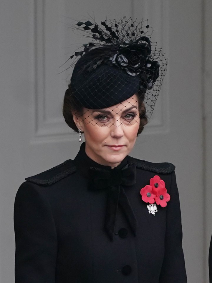 a woman wearing a black hat with a flower on it