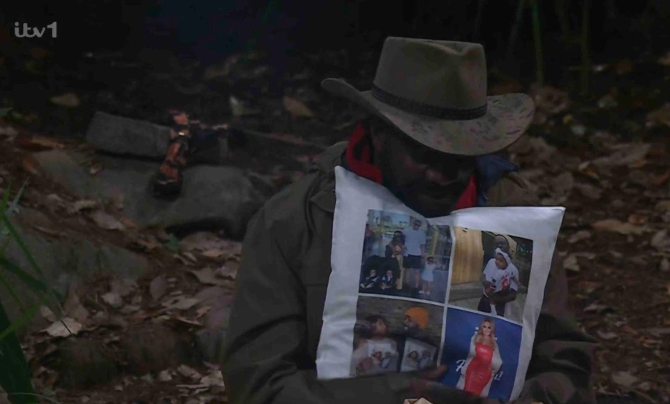 a man in a cowboy hat is holding a pillow with pictures on it