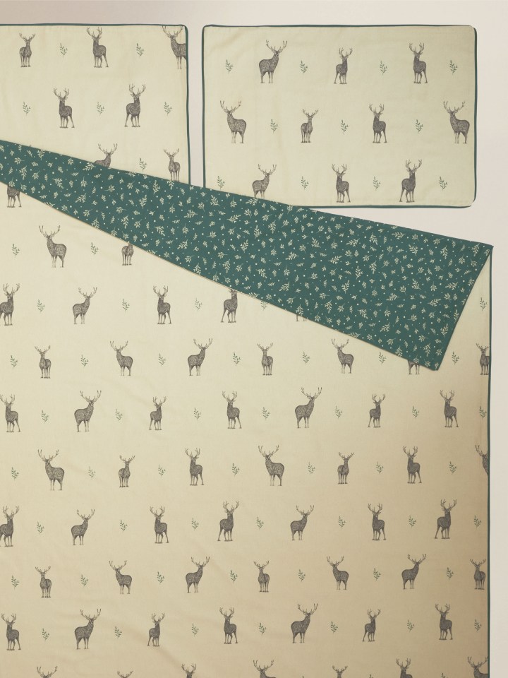 a bedspread with a pattern of deer on it