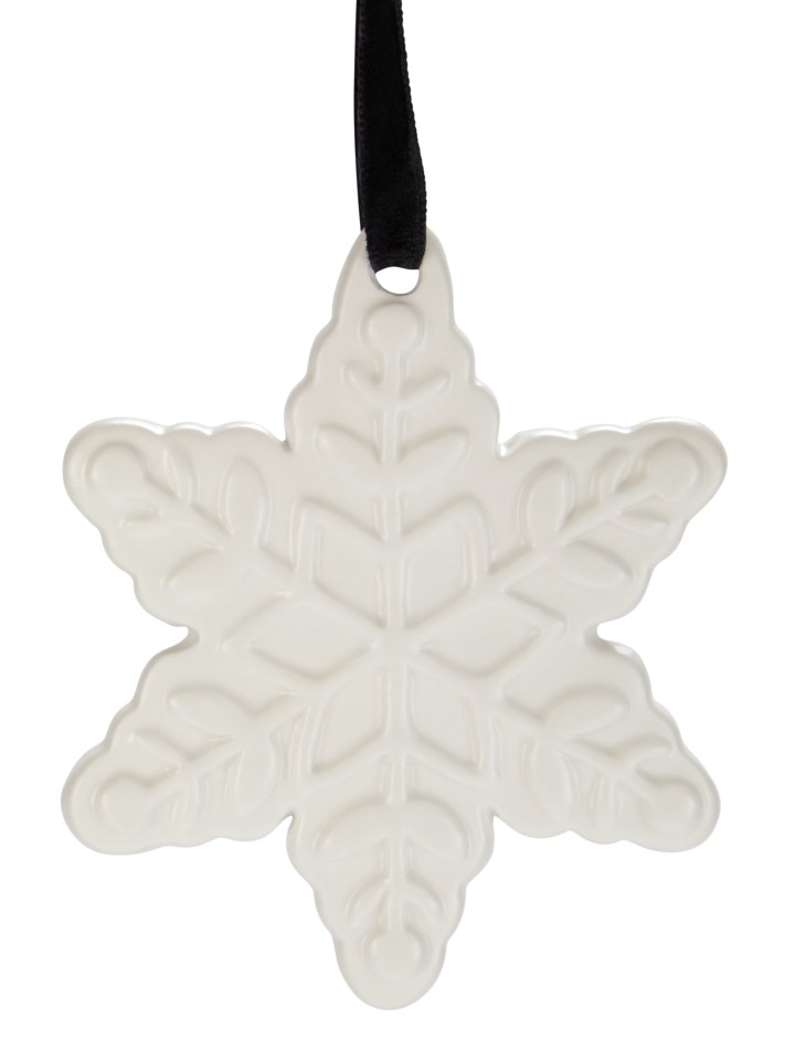 a white snowflake ornament hangs from a black ribbon