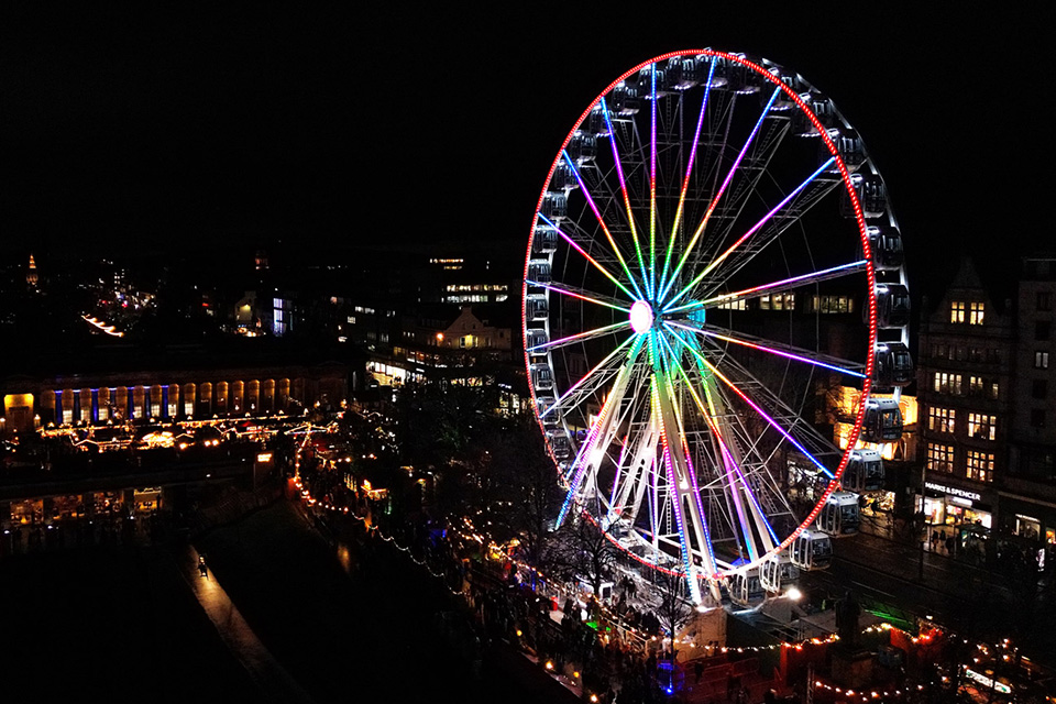 a large ferris wheel is lit up at night