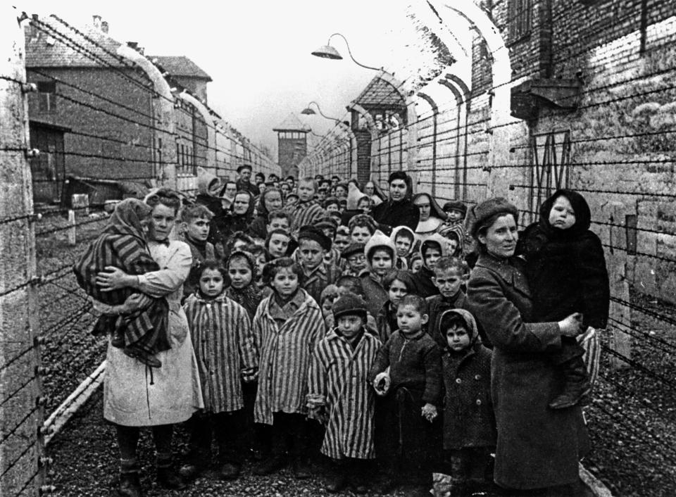 a group of people standing in front of a barbed wire fence