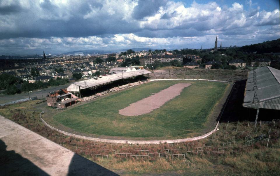 an empty stadium with a city in the background