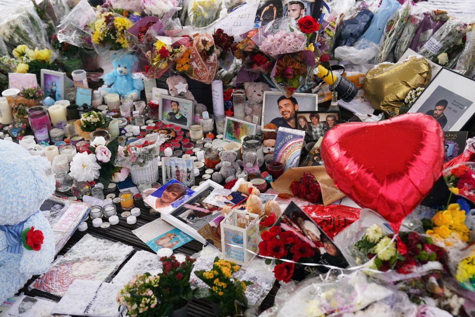 a heart shaped balloon is surrounded by flowers and candles