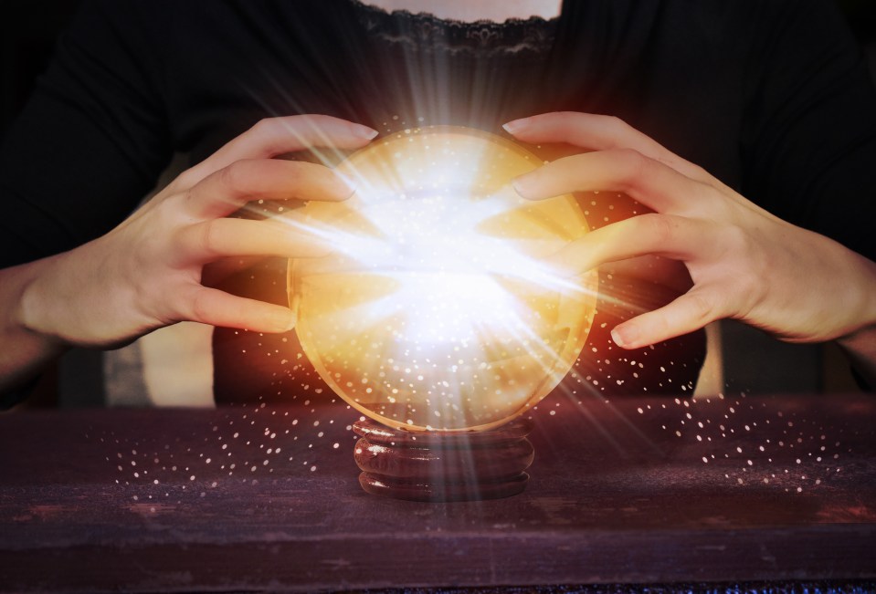 a woman is holding a crystal ball with a light coming out of it