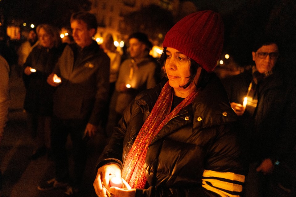 Friends hold candles while remembering Mackenzie Michalski during a vigil