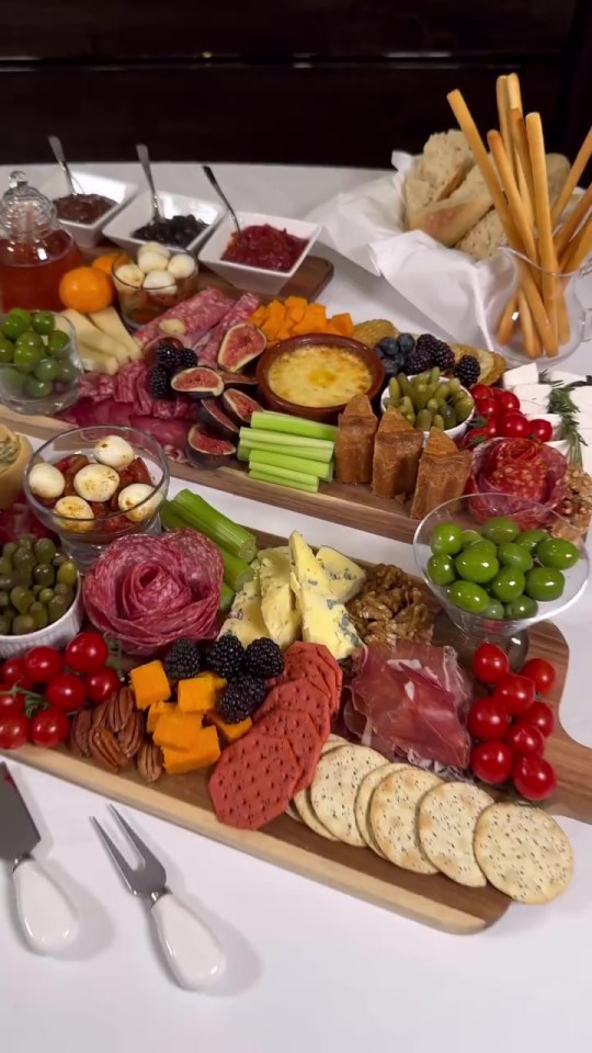 a table topped with a variety of food including cheese crackers and olives