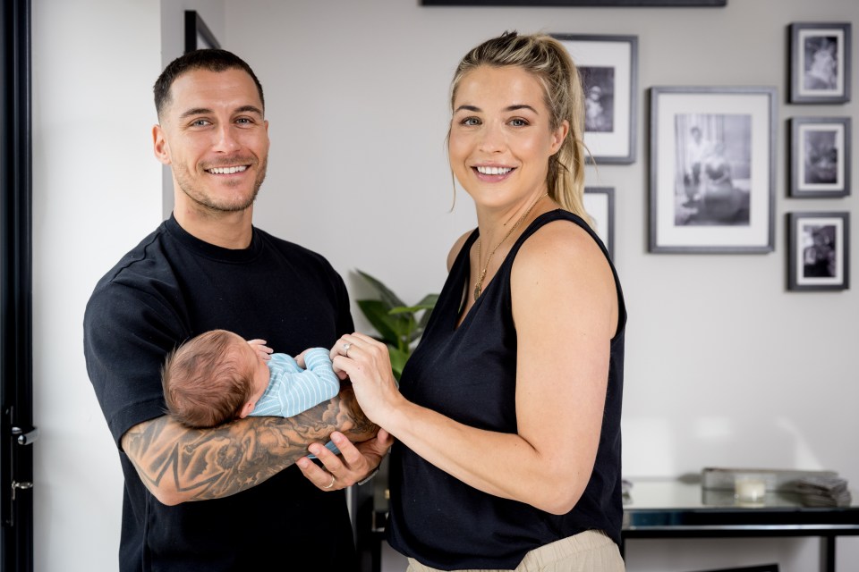 a man and woman holding a baby in a living room