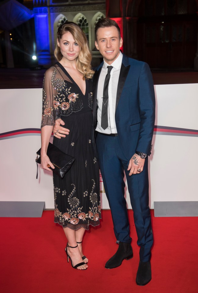 a man and woman are posing for a picture on a red carpet