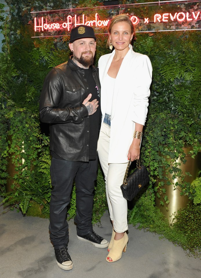 a man and woman pose in front of a sign that says house of harlow